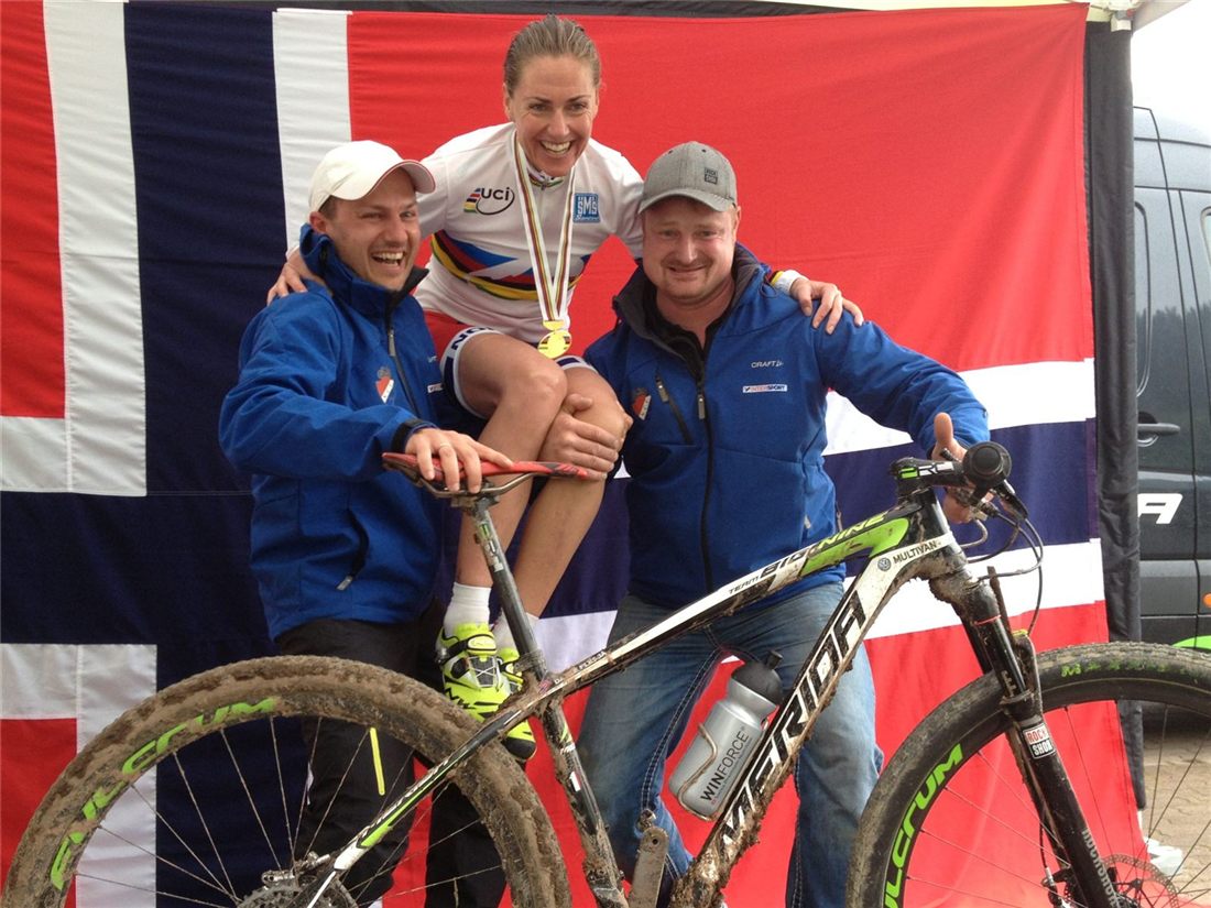 Gunn-Rita Dahle Flesjå with gold medal and two support staff at the 2012 MTB Marathon World Championships
